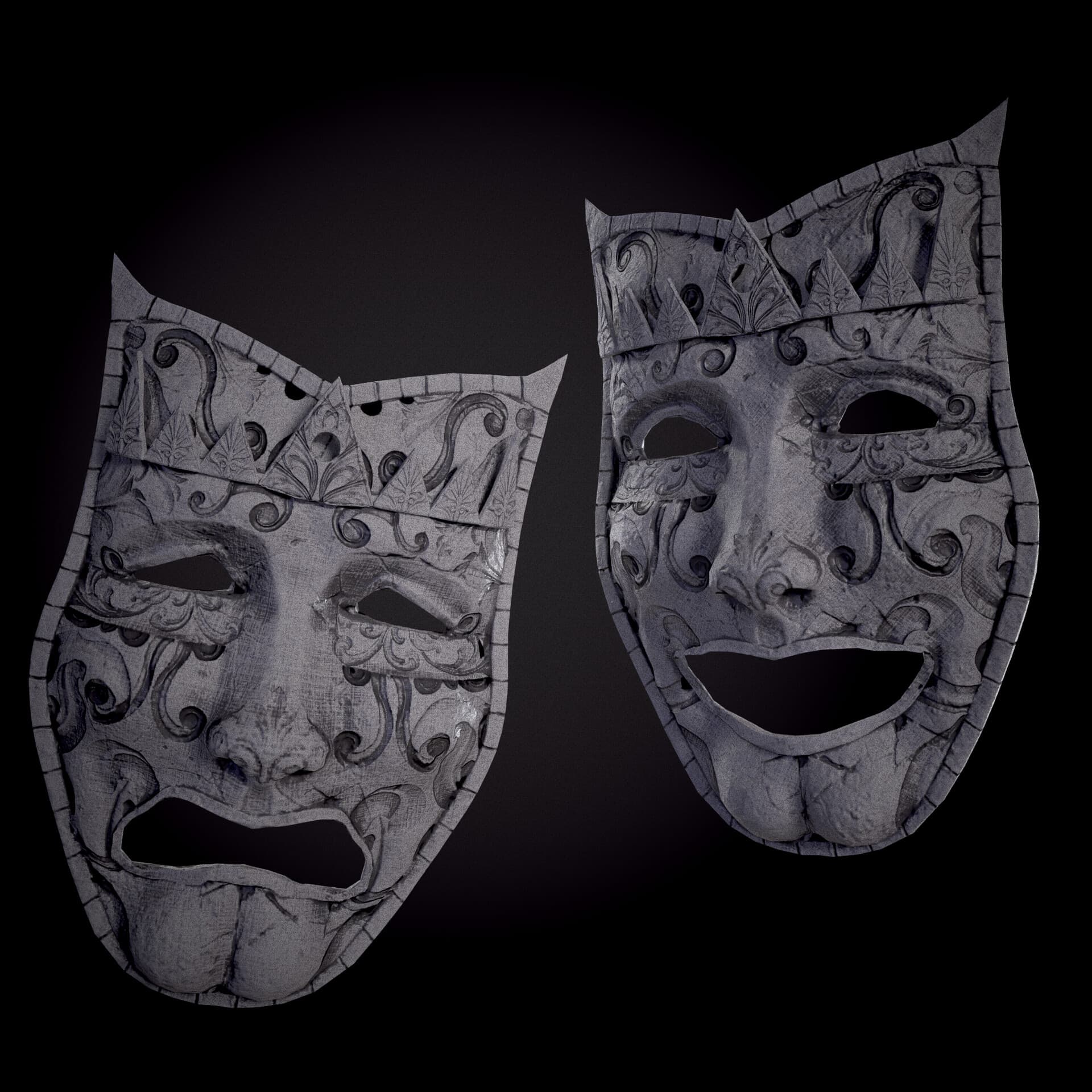 Two sculpted theatrical masks with intricate engraved surfaces